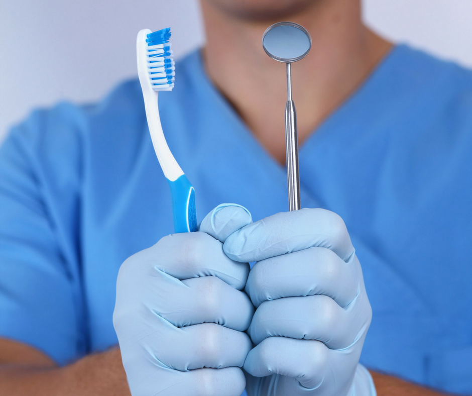 A Budapest dentist with a tooth brush and a dental mirror in his hands.